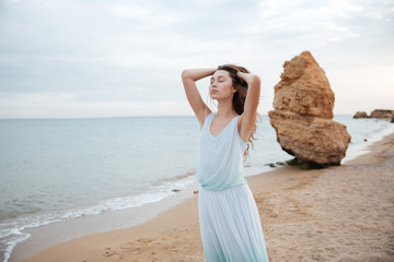 Fototapeta na wymiar Sensual woman standing with eyes closed on the beach
