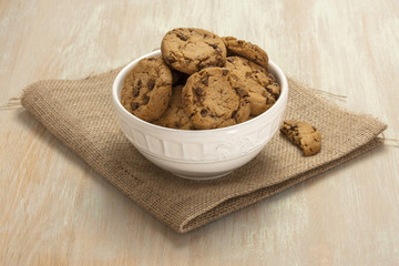Bowl of chocolate chips cookies on burlap with copyspace