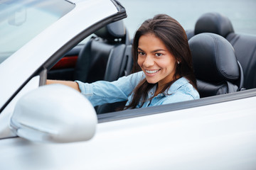 Portrait of young girl driving cabriolet