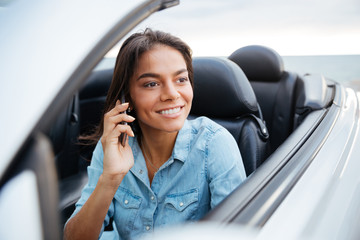 Beautiful woman driving car and talking on mobile phone