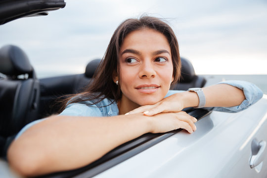 Portrait of smiling woman sitting in her convertible car