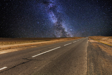 Cracked desert road under the magnificent starry sky