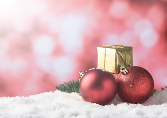 christmas balls and small gift in snow,ligths bokeh background