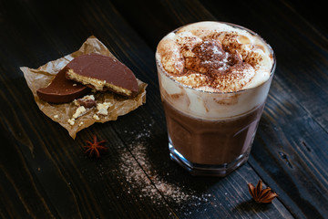 hot chocolate with chocolate wafers on the black table