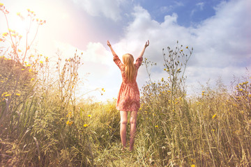 young woman relaxing with arms raised to the sky in the middle of the nature - obrazy, fototapety, plakaty