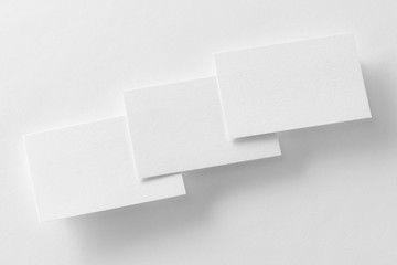 Mockup of three business cards row at white textured paper
