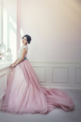Woman beautiful and happy pink interior and pink long dress