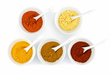 Porcelain bowls with various herbal spices on white background