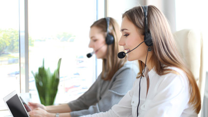 Portrait of call center worker accompanied by her team. Smiling customer support operator at work.