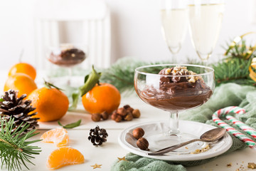 Chocolate pudding mousse with avocado, nuts and christmas decorations. Delicious Christmas themed dinner table.