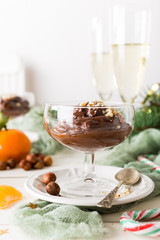 Chocolate pudding mousse with avocado, nuts and christmas decorations. Delicious Christmas themed dinner table.