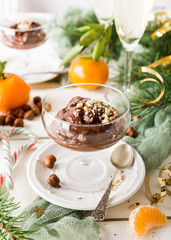 Chocolate pudding mousse with avocado, nuts and christmas decorations. Delicious Christmas themed dinner table.