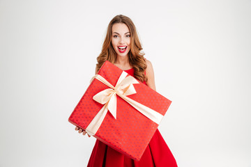 Fototapeta premium Woman in santa claus dress giving you big red gift