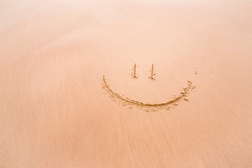 Soft smile drawn on wet sand by the waves on the shore. Background.