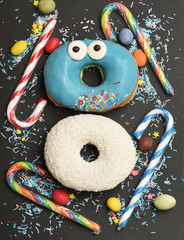 Funny glazed donuts on black background
