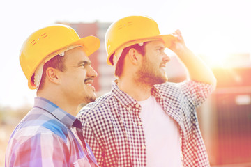 group of smiling builders in hardhats outdoors