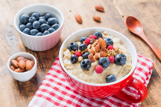 Porridge bowl, oats porridge with blueberries and almonds in red bowl