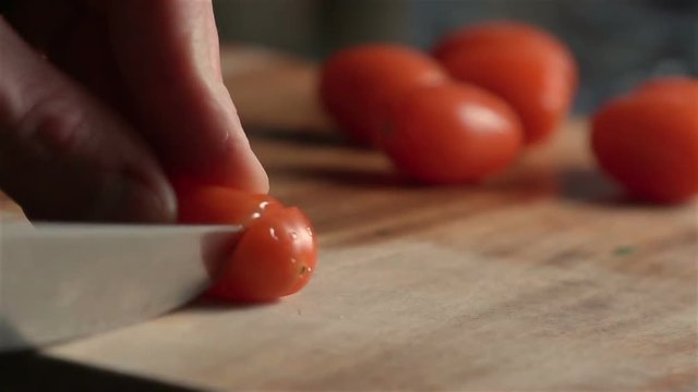 Slow motion of little tomatoes slicing. Find similar in our portfolio.