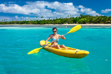 Woman Kayaking in the Ocean on Vacation in tropical Fiji island