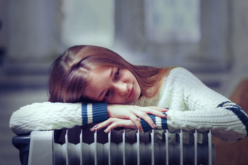 long-haired woman near electric heater at home