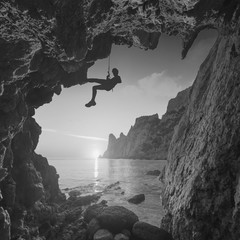 Silhouette of climber in a mountain cave. Monochrome