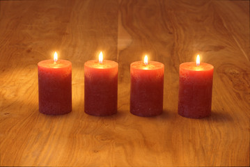 Fototapeta na wymiar Vier brennende Kerzen auf Holztisch