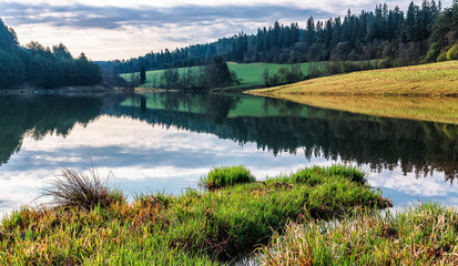 Reflection of clouds and forest in Zlatna lake, Slovakia