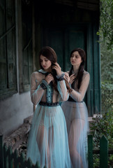 Two sexy brunettes in elegant vintage dresses, sorrowful image