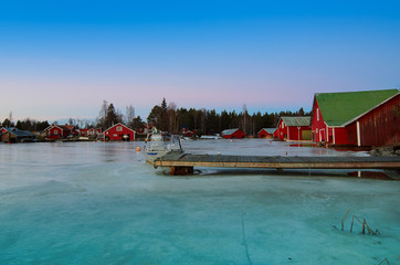 Fototapeta na wymiar Fisherman village in Sweden at winter after sunset - winter seasonal scandinavian background