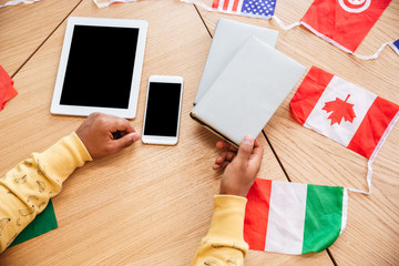 Table with blank screen smartphone, tablet and flags of countries