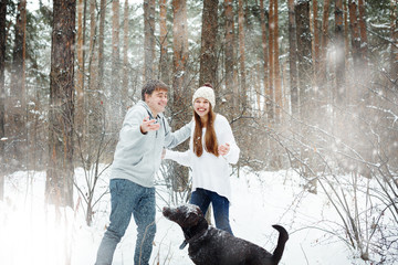 Young funny couple having fun in snowy forest