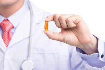 Omega 3 fish oil capsule hold by a male doctor hand