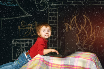 Naklejka premium Little kids with laptop on a Christmas background . A Letter To Santa Claus