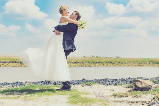 Br&auml;utigam h&auml;lt Braut in die Luft - Flitterwochen