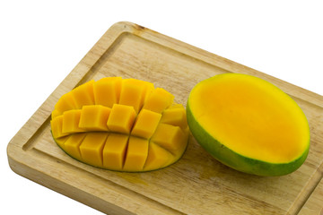Fresh ripe mango cut into pieces on cutting board / Mango cut in a grid pattern and whole mango on white background / Fresh Mango on cutting wood board / Sweet Mango ripe on white background