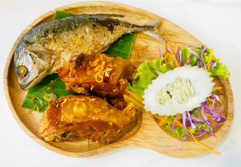 Fried mackerel fish adn fried chicken on wooden dish