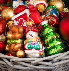 Christmas or New Year background: basket with colored glass toys and balls, decoration and gifts on wooden background