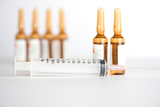Injection syringe and brown ampule background