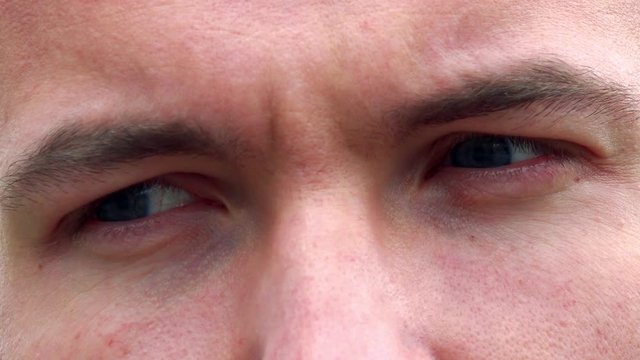 Young sad man looks around - detail of eyes expression 