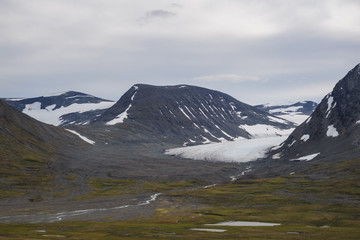 Glacier tongue in mountain valley transferring in green river and lakes landscape
