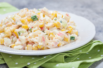 Salad with crab sticks, corn, cucumber, and eggs