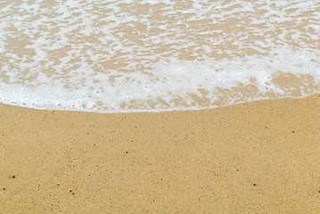 Fototapeta na wymiar Soft wave on sand beach. Selective focus