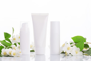 empty tubes of cream on a white background with flowers