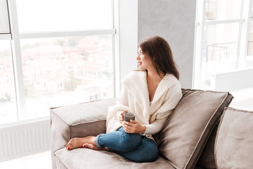 Wman with cup of coffee sitting and dreaming at home