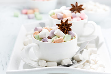 cocoa with colorful marshmallows and spices in cups