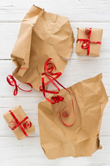 Weihnachtsgeschenke auspacken auf einem weißen Holztisch