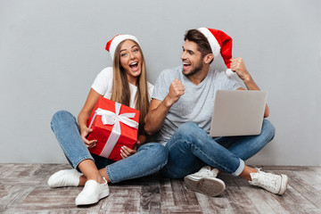Merry christmas couple with laptop and gift