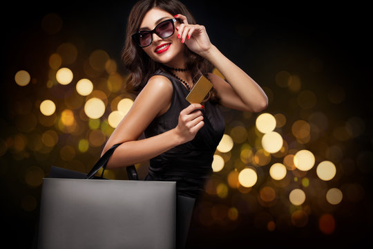 Shopping woman holding grey bag on new year background with lights bokeh in black friday holiday