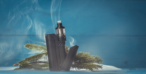 vaporizer with a black box on a blue background with fir branches