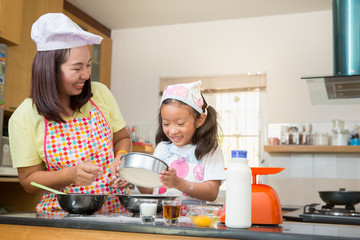 Asian family enjoy making pancake in kitchen